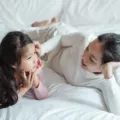 Seorang ibu yang tersenyum sambil mendengarkan penjelasan anaknya untuk mengajari anak berani jujur