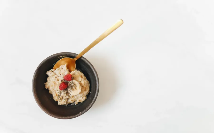 Berbagai pilihan makanan sehat untuk penderita maag seperti oatmeal dan pisang di atas meja kayu
