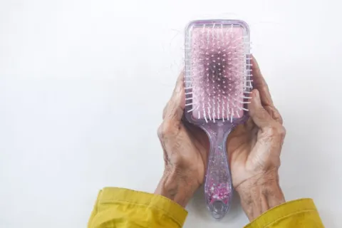 Ilustrasi cara mengatasi rambut rontok dengan perawatan rambut alami menggunakan minyak kemiri dan kelapa